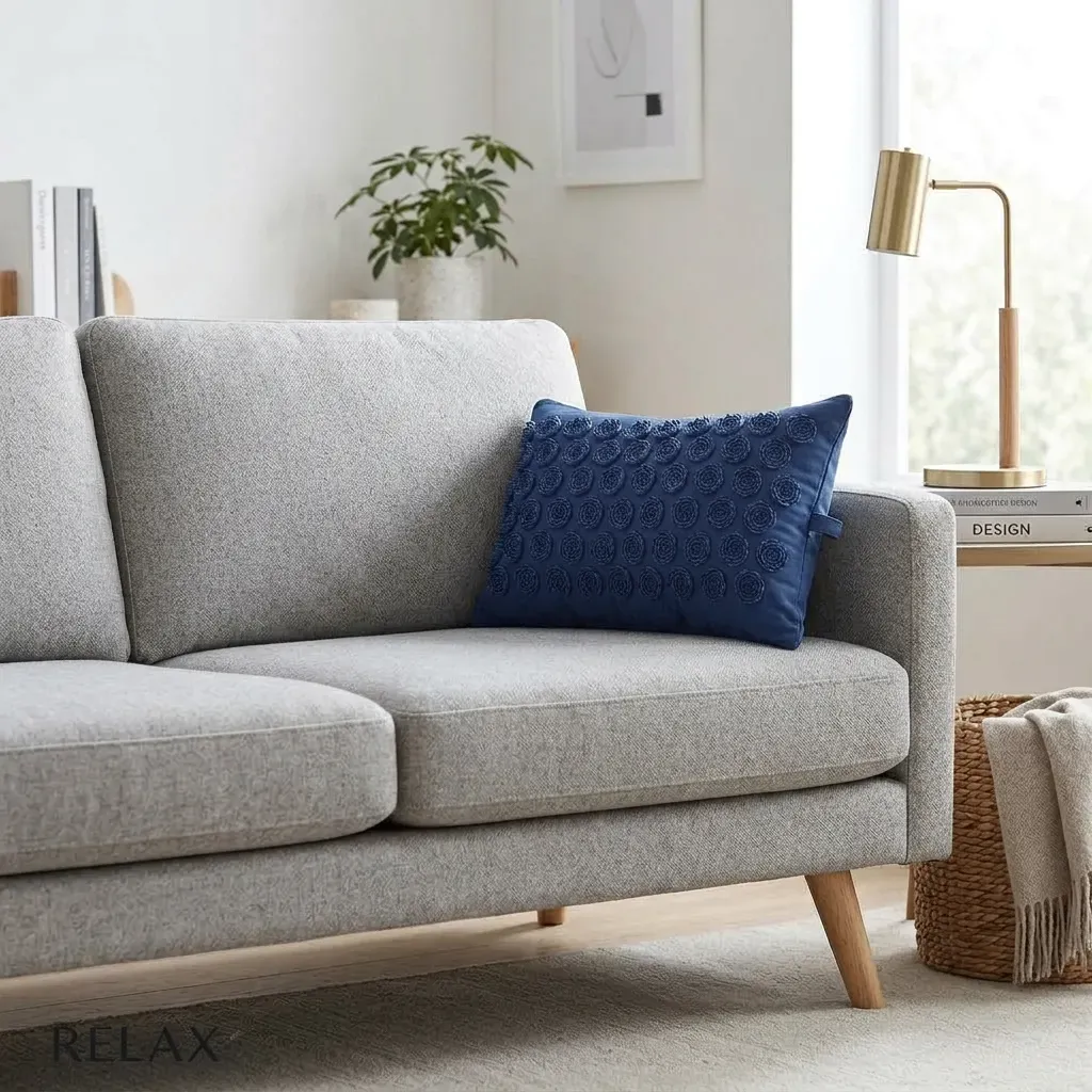 coussin d'acupression bleu posé sur un canapé gris
